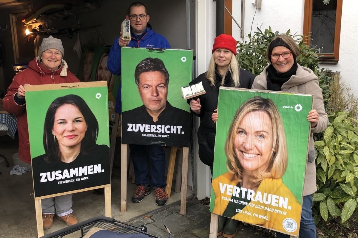 Mitglieder des Ortsverbands halten die frisch beklebten Plakate mit Baerbock, Habeck und Verena Machnik Fotos